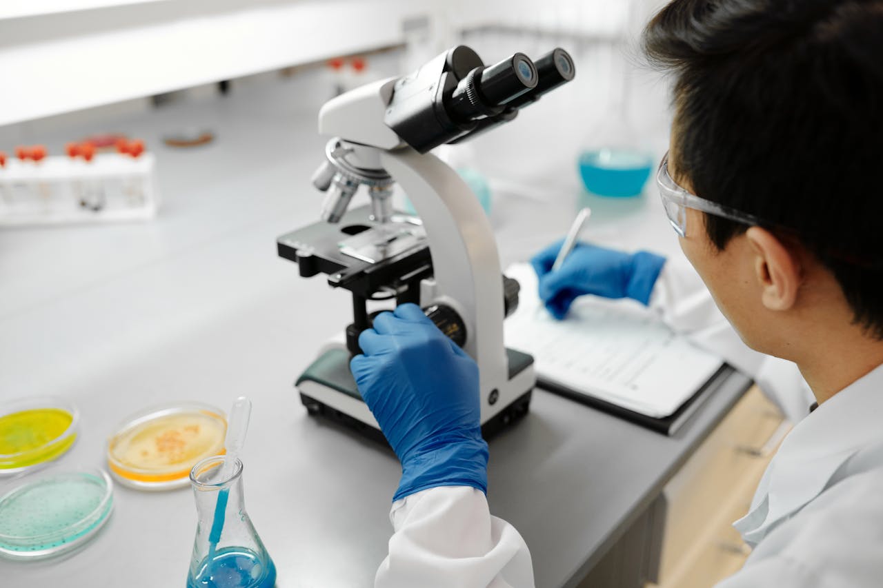 services-02 Scientist using a microscope to analyze samples in a modern laboratory environment.